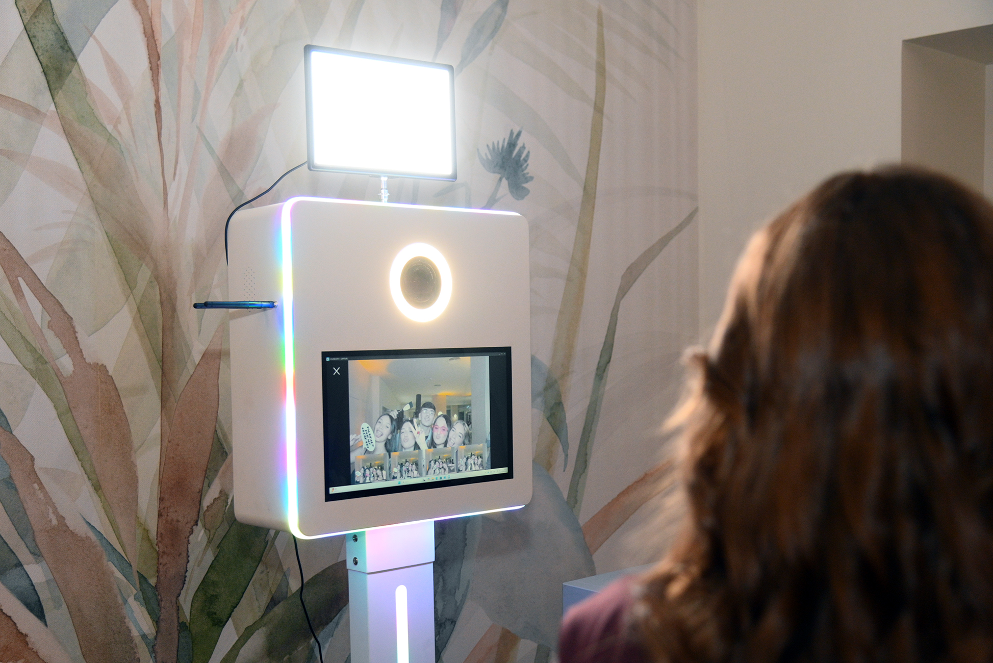 Primo piano del photobooth con luce ad anello e anteprima degli scatti