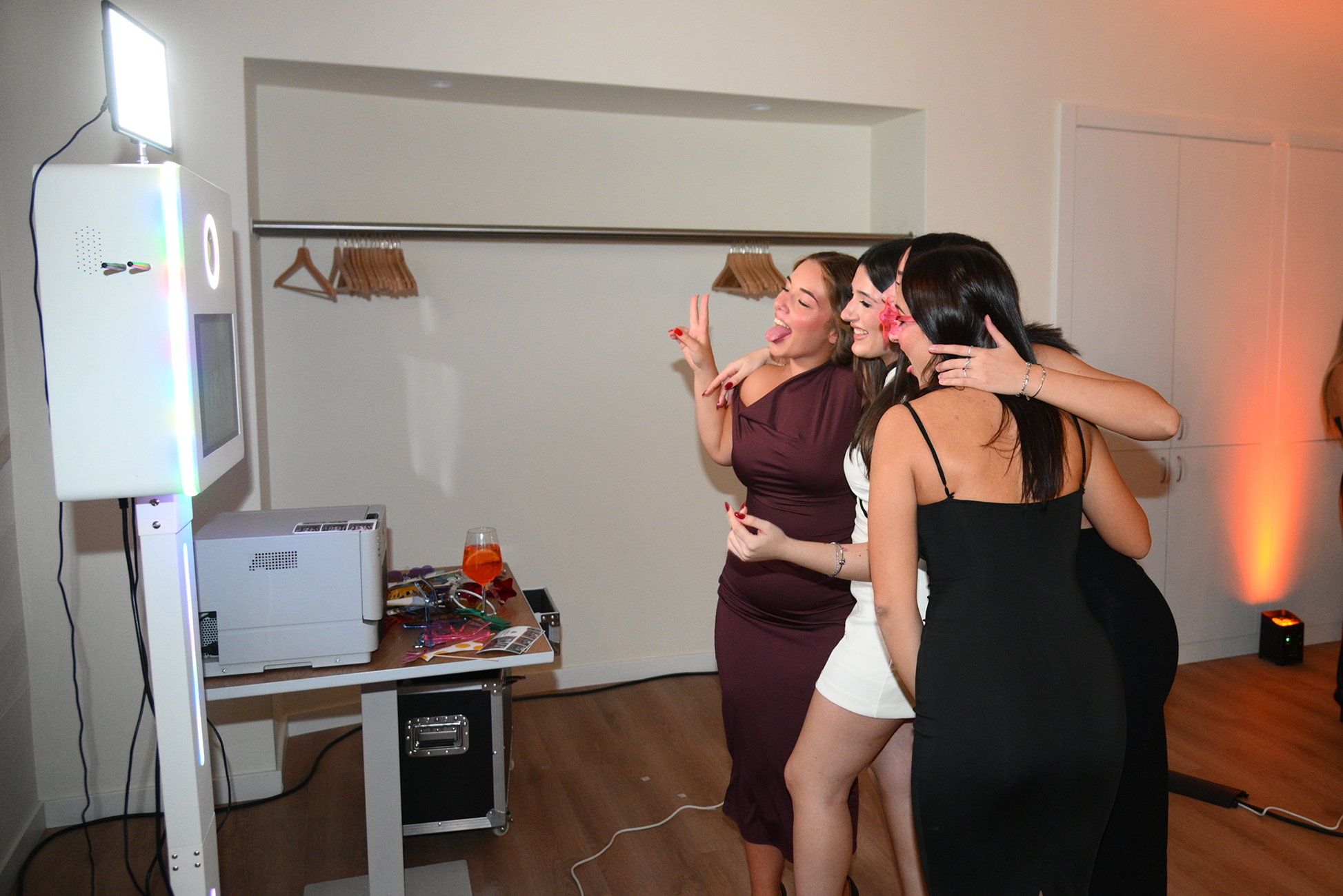 Un gruppo di amiche posa davanti al photobooth durante una festa