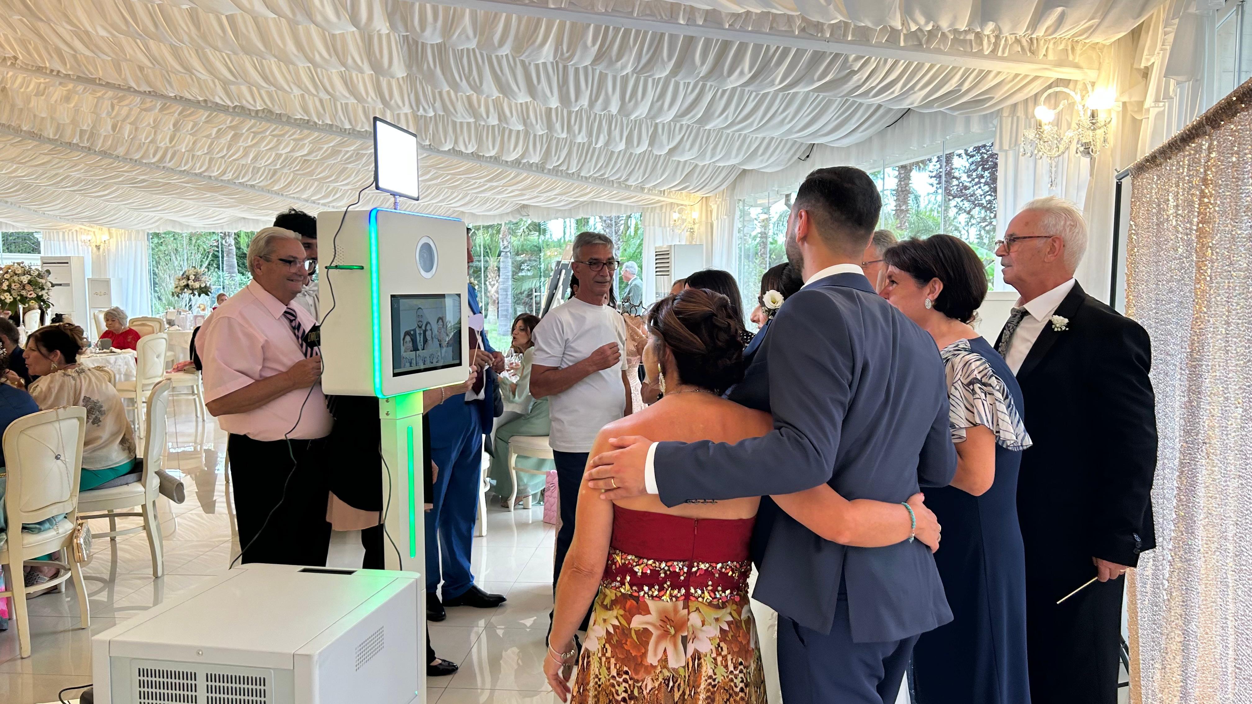 Il photobooth in una sala ricevimenti con invitati in coda per farsi fotografare